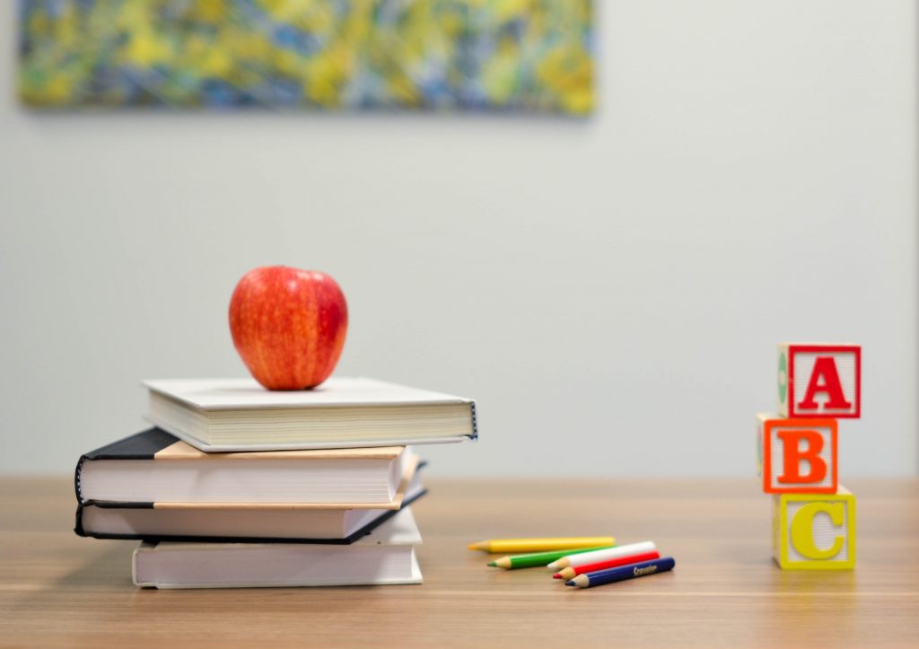 apple and books and pencils on table, representing school in general